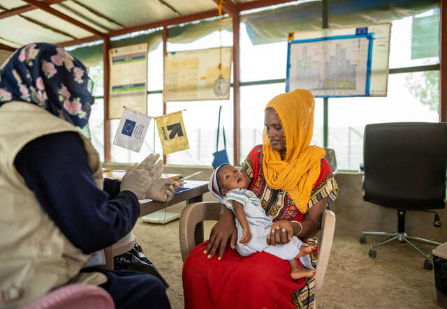 A Sudanese mother holding her baby during a health consultation
